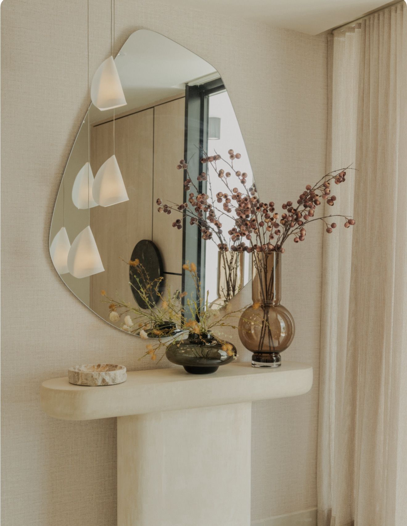 Primary suite with brass sconces and bouclé chair.